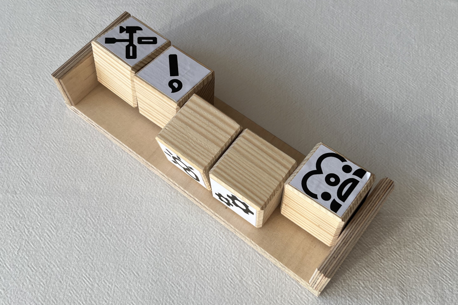 AND logic model: Five wooden cubes in a bar, where only two symbols are visible, for an incomplete condition chain to show.